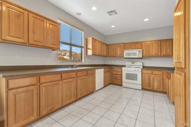 kitchen with sink, light tile patterned floors, and white appliances