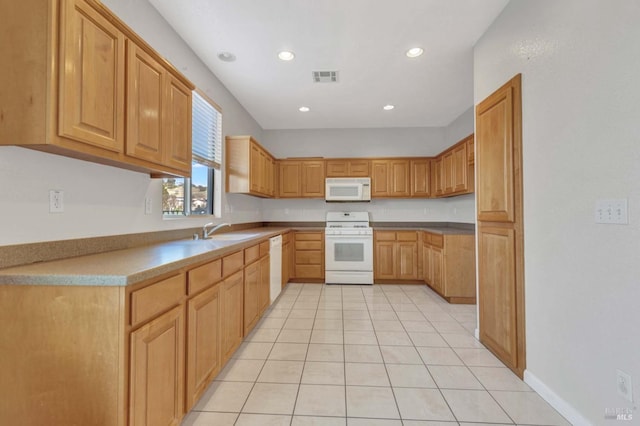 kitchen with white appliances, sink, and light tile patterned floors