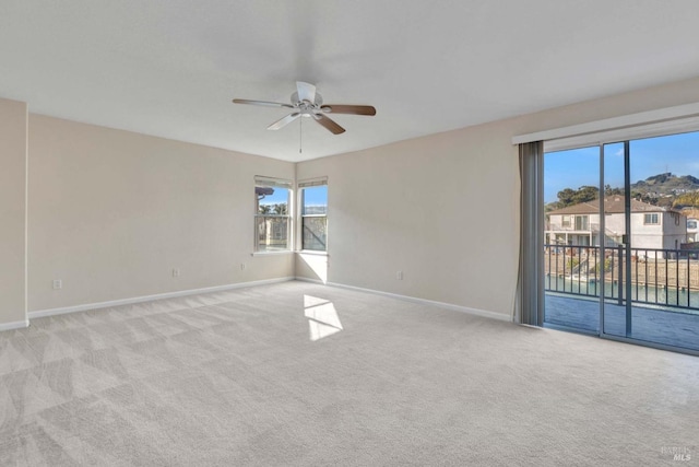 carpeted spare room with ceiling fan