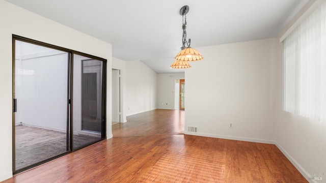 unfurnished room with visible vents, baseboards, and wood finished floors