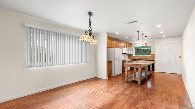 kitchen with visible vents, tasteful backsplash, white appliances, light wood finished floors, and baseboards