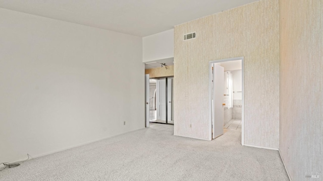 unfurnished bedroom featuring baseboards, visible vents, carpet floors, and connected bathroom