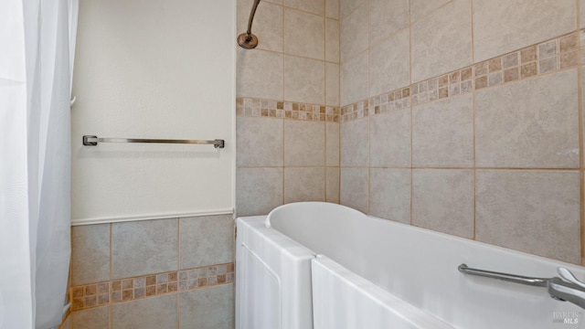 bathroom featuring tile walls and a tub to relax in