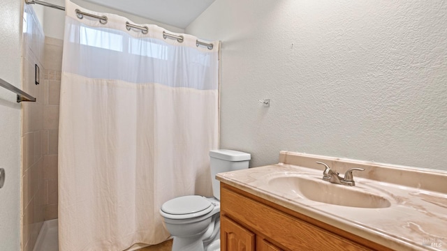 bathroom featuring vanity, toilet, a textured wall, and shower / bath combo with shower curtain