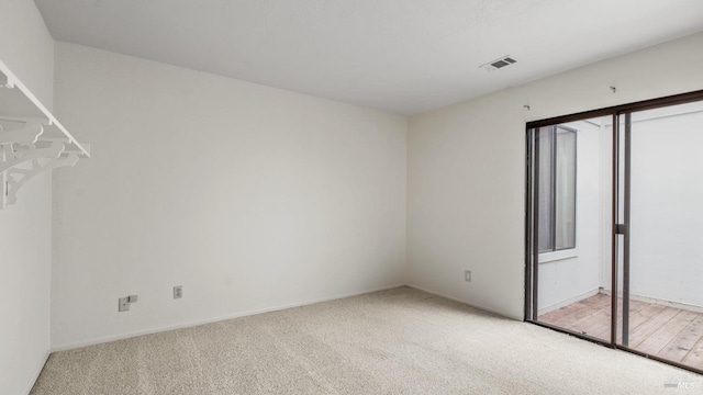 unfurnished bedroom featuring light carpet, visible vents, and baseboards