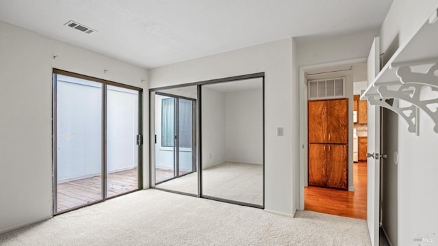 unfurnished bedroom with visible vents and carpet flooring