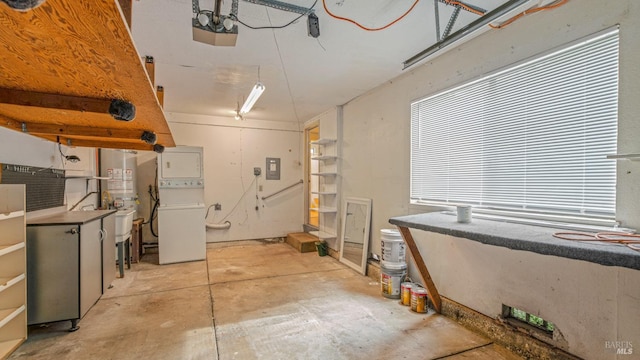 interior space with gas water heater, concrete flooring, and stacked washing maching and dryer