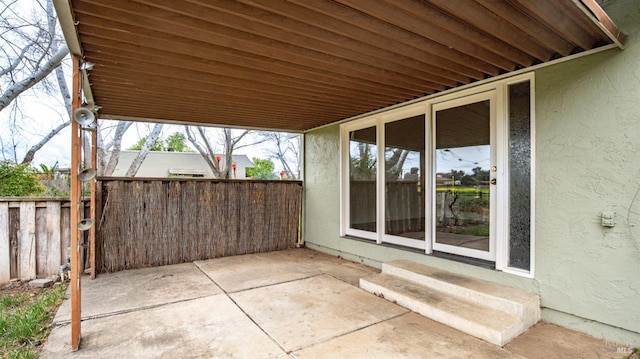 view of patio featuring entry steps and fence