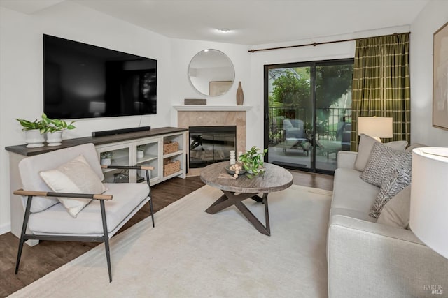 living room with a tile fireplace and hardwood / wood-style floors