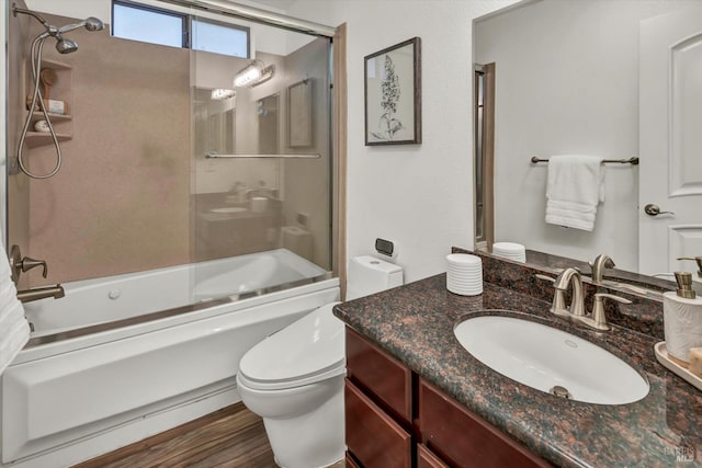 full bathroom featuring enclosed tub / shower combo, vanity, wood-type flooring, and toilet