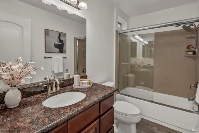 full bathroom featuring toilet, vanity, shower / bath combination with glass door, and hardwood / wood-style floors