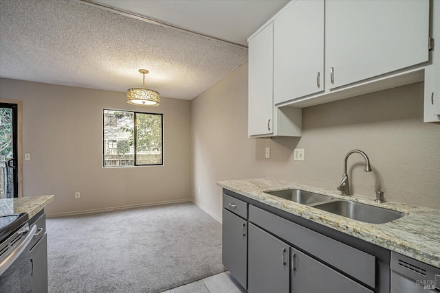 kitchen with baseboards, light colored carpet, dishwashing machine, a textured ceiling, and a sink