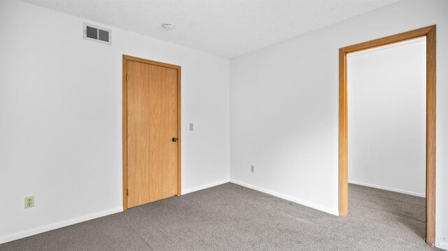 unfurnished bedroom with a closet, baseboards, a textured ceiling, and carpet