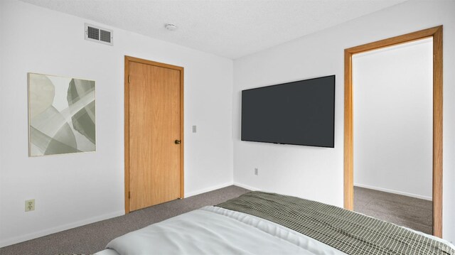 spare room with visible vents, light carpet, a textured ceiling, and baseboards