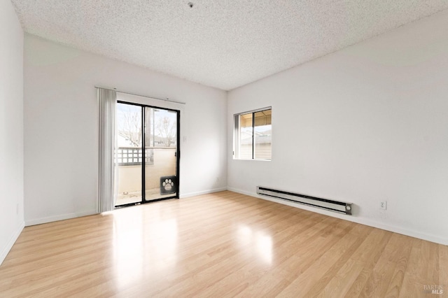 empty room featuring a baseboard radiator, a textured ceiling, and light hardwood / wood-style floors