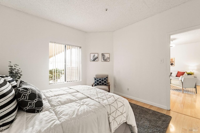 bedroom featuring hardwood / wood-style flooring and a textured ceiling