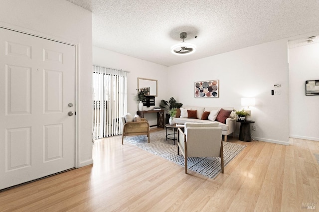 living room featuring a textured ceiling and light wood-type flooring