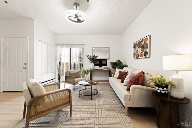 living room with a baseboard radiator, a textured ceiling, and light wood-type flooring