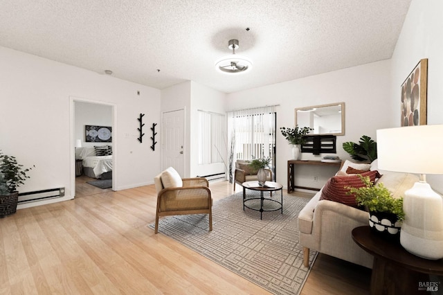 living room with a textured ceiling, baseboard heating, and light wood-type flooring