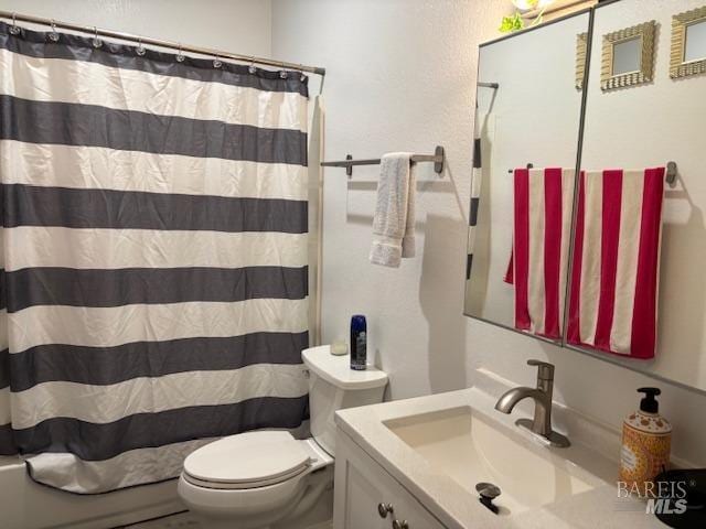 bathroom featuring a shower with curtain, vanity, and toilet