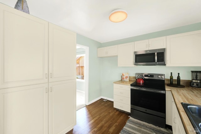 kitchen featuring sink, wooden counters, appliances with stainless steel finishes, dark hardwood / wood-style floors, and white cabinets