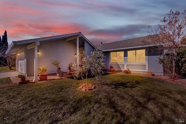 exterior space featuring a garage and a lawn