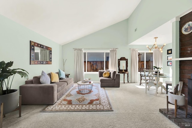 living room with an inviting chandelier, high vaulted ceiling, and carpet