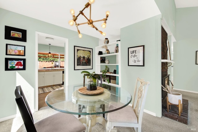 carpeted dining space featuring a notable chandelier