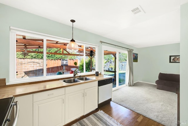 kitchen featuring sink, white cabinetry, stainless steel appliances, dark hardwood / wood-style floors, and decorative light fixtures