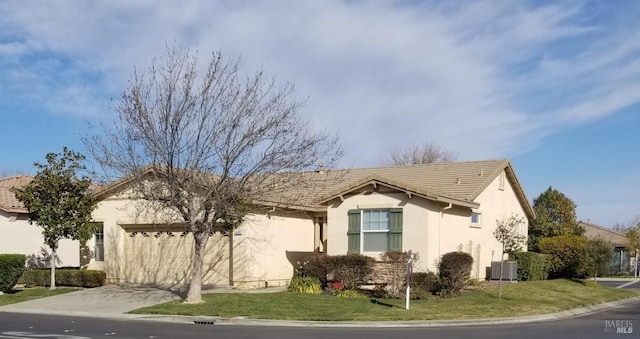 ranch-style home with a garage and a front lawn