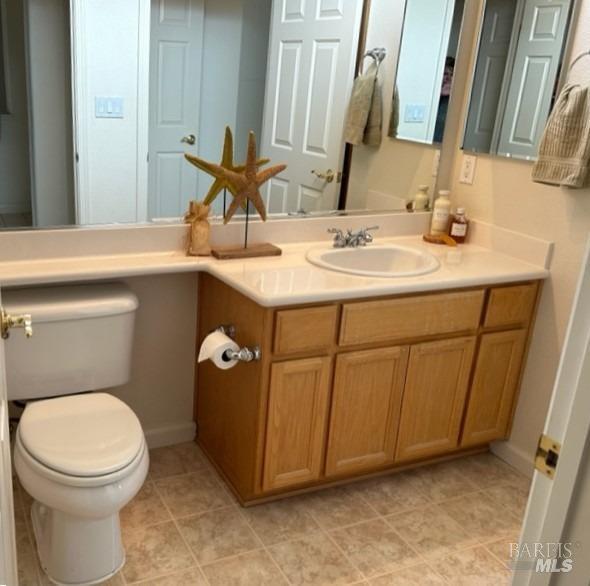 bathroom featuring vanity, tile patterned flooring, and toilet