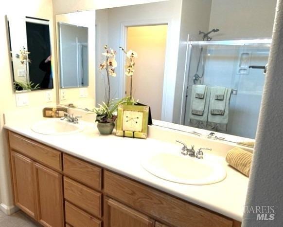 bathroom with vanity and a shower with door