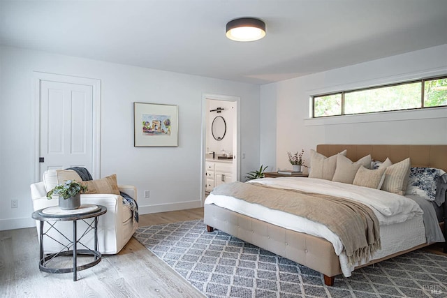 bedroom featuring ensuite bath and light hardwood / wood-style flooring