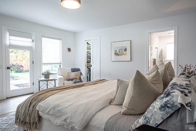 bedroom with wood-type flooring, access to outside, and a closet