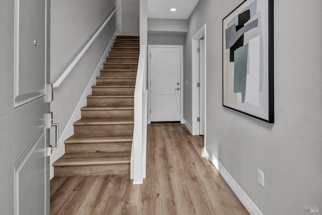 staircase with hardwood / wood-style flooring
