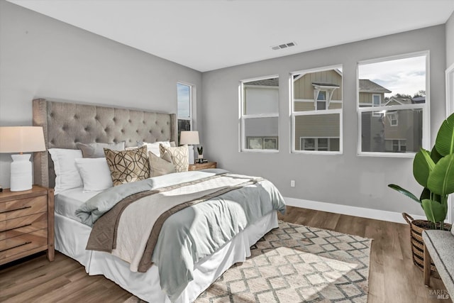 bedroom with wood-type flooring and multiple windows