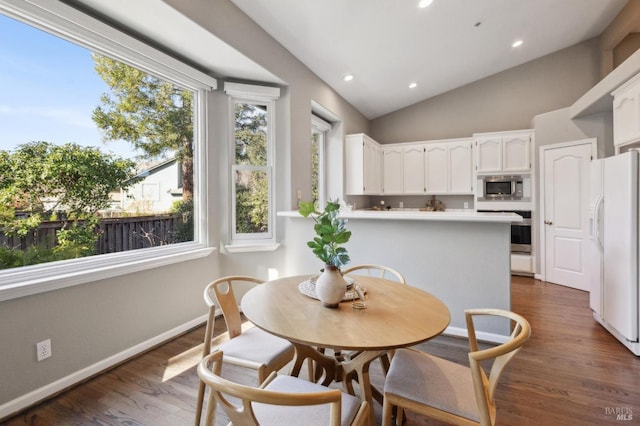 dining space with vaulted ceiling and dark hardwood / wood-style flooring