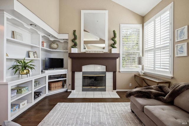 living room with vaulted ceiling, dark hardwood / wood-style floors, and a fireplace