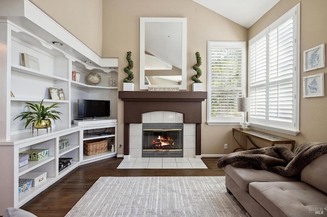 living room featuring vaulted ceiling, a fireplace, and dark hardwood / wood-style flooring