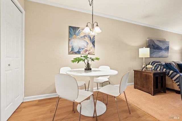 dining room with an inviting chandelier, crown molding, and wood-type flooring