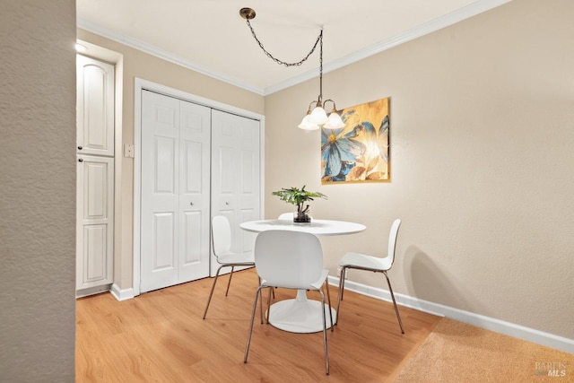 dining area featuring ornamental molding, a chandelier, and light hardwood / wood-style flooring