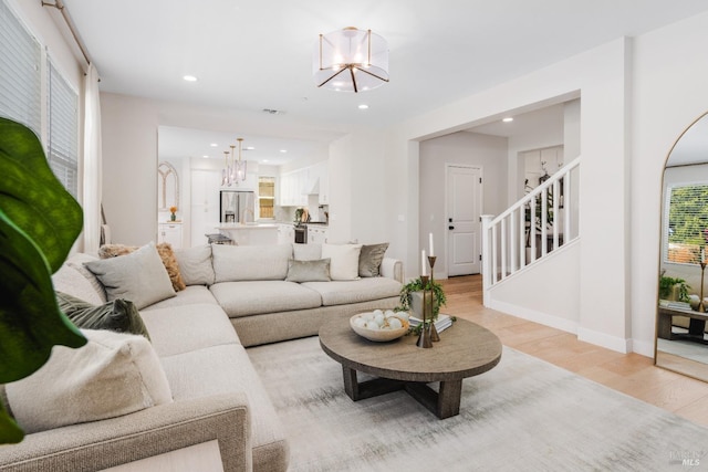 living room featuring an inviting chandelier and light wood-type flooring