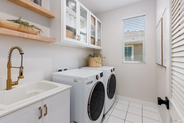 laundry area featuring cabinets, sink, light tile patterned floors, and independent washer and dryer