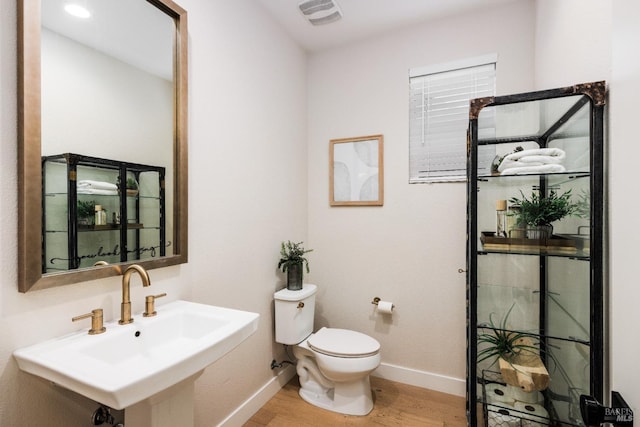 bathroom featuring sink, hardwood / wood-style floors, and toilet