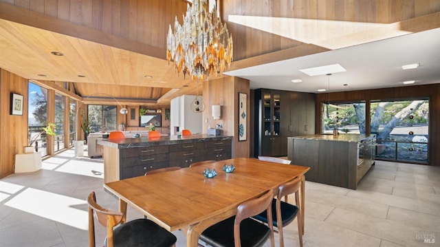 dining room featuring wood ceiling, a notable chandelier, wooden walls, and light tile patterned floors