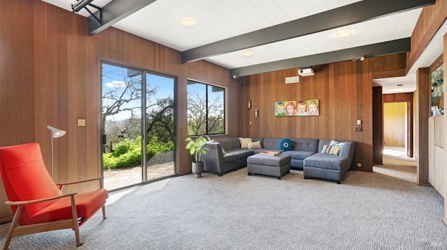 living room with beamed ceiling, wooden walls, and carpet