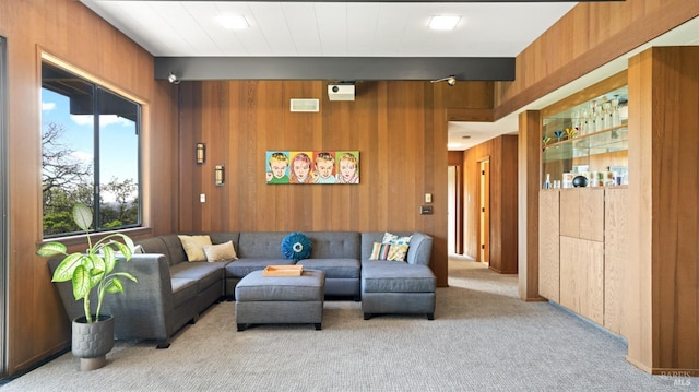 living room with light carpet and wooden walls