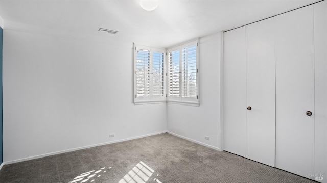 unfurnished bedroom with light carpet and a closet