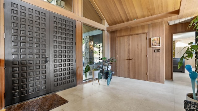 foyer with wooden ceiling, lofted ceiling, and wood walls