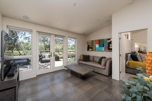 tiled living room featuring vaulted ceiling and french doors